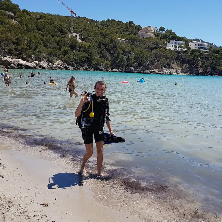 Ania w sprzęcie nurkowym wychodzi z morza na plażę