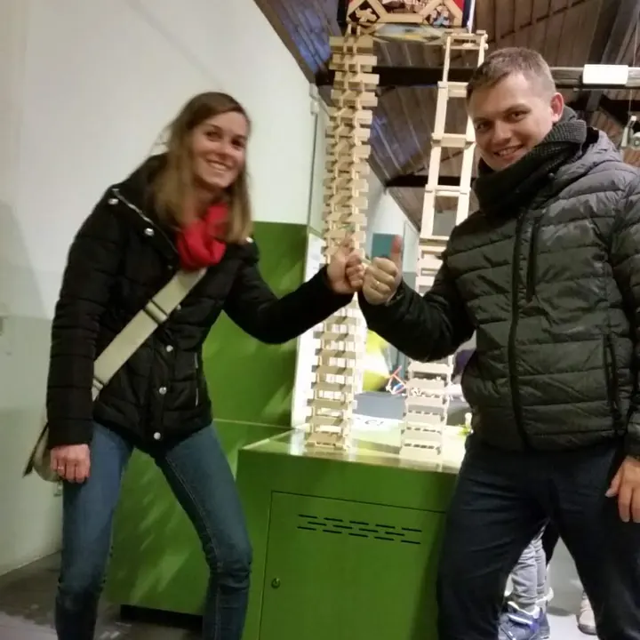 Ania i Piotr przybijają żółwika przy wieży z drewnianych klocków